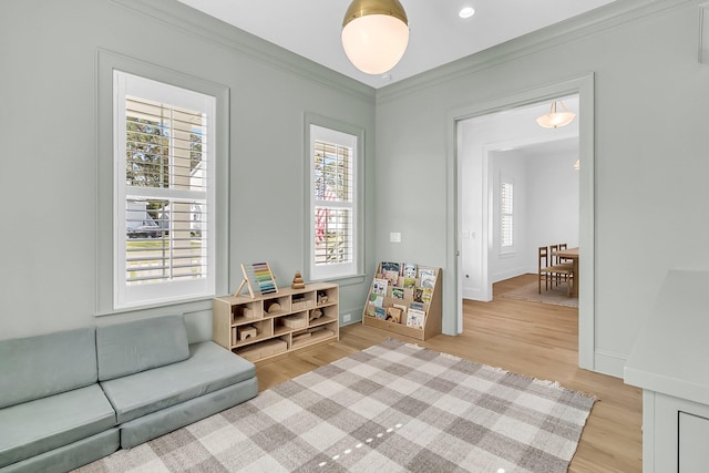 game room with light wood-style flooring, baseboards, and ornamental molding