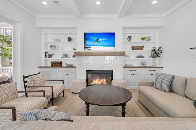 living room with built in shelves, beam ceiling, recessed lighting, light wood-style floors, and a fireplace