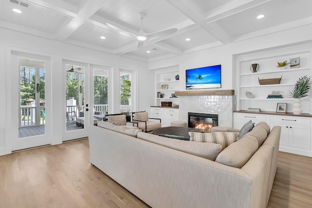 living area featuring a healthy amount of sunlight, built in shelves, and light wood-type flooring