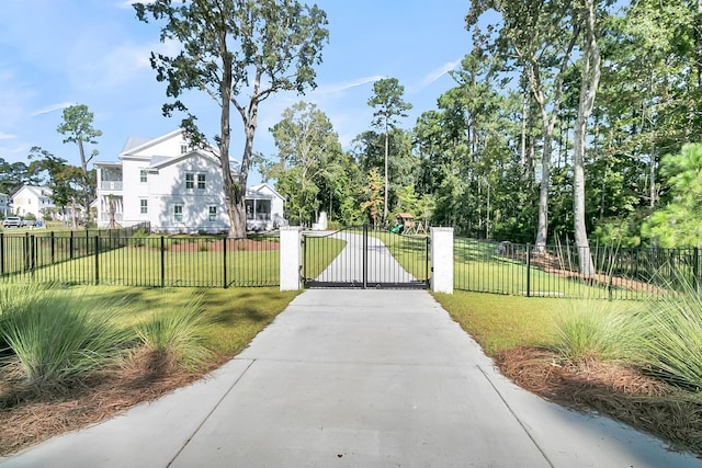 view of gate with a lawn, a residential view, and a fenced front yard