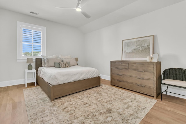 bedroom featuring baseboards, lofted ceiling, and wood finished floors