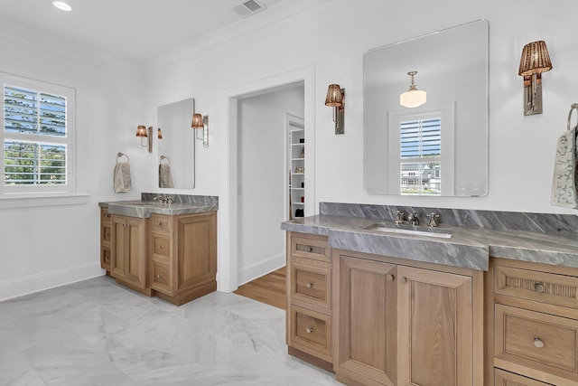 bathroom featuring crown molding, two vanities, visible vents, and a sink