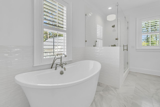 bathroom featuring a soaking tub, a stall shower, and tile walls