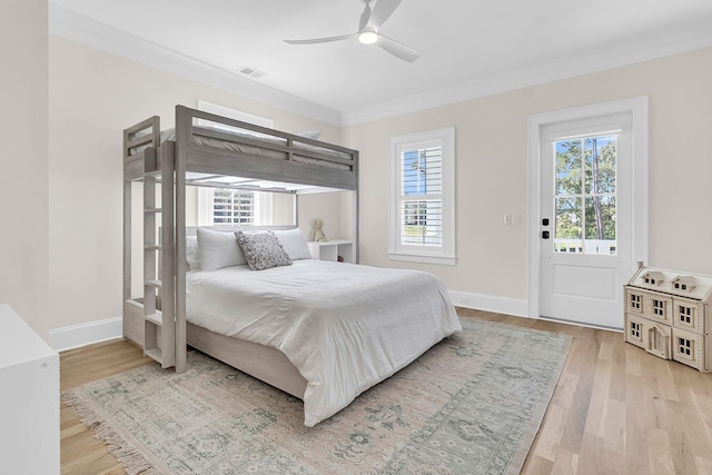 bedroom featuring visible vents, baseboards, crown molding, and light wood finished floors