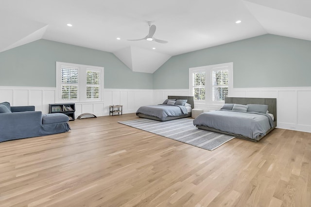 bedroom featuring a ceiling fan, a wainscoted wall, lofted ceiling, light wood-style flooring, and recessed lighting