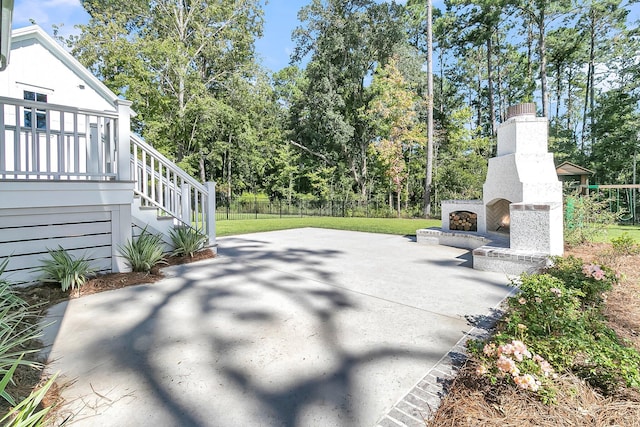 view of patio with stairs, fence, and an outdoor fireplace