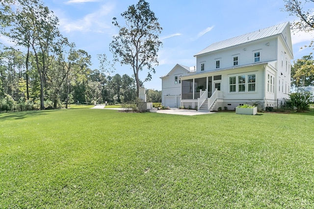 rear view of property with crawl space, metal roof, a yard, and a sunroom