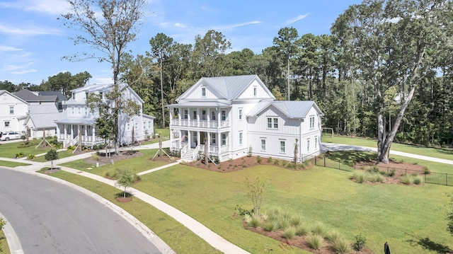 view of front of home featuring a front lawn, a porch, fence, board and batten siding, and metal roof