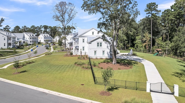 exterior space with a residential view, a front lawn, and fence