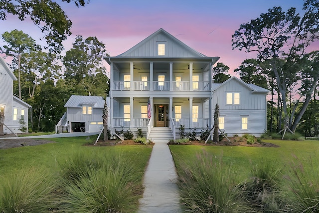 view of front of property with a porch, a balcony, board and batten siding, and a front lawn