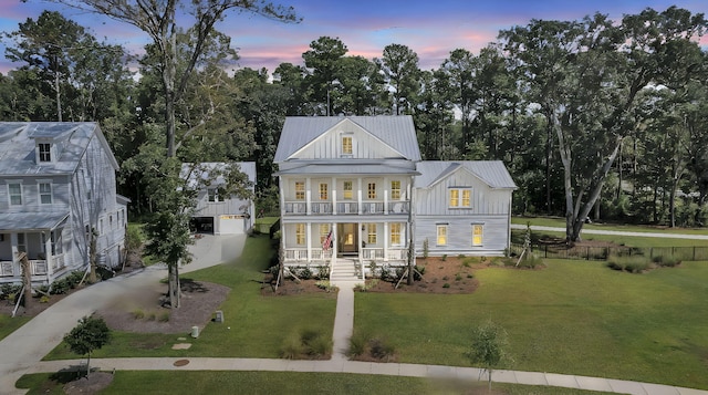 view of front of home featuring a yard, a balcony, a porch, and board and batten siding