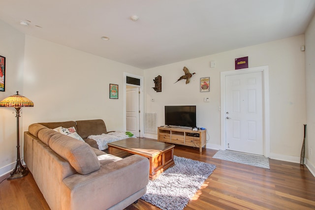 living area featuring wood finished floors, visible vents, and baseboards