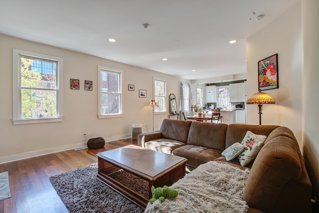 living area featuring recessed lighting, baseboards, and wood finished floors