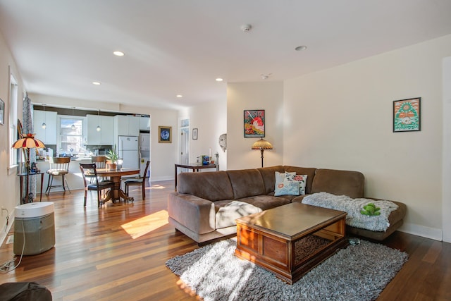 living room with recessed lighting, baseboards, and wood finished floors