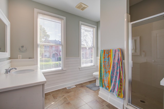 bathroom with visible vents, a shower stall, toilet, wainscoting, and vanity