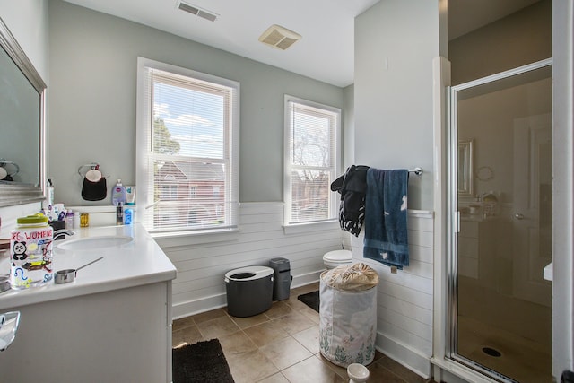 full bath featuring visible vents, a stall shower, vanity, and a wainscoted wall
