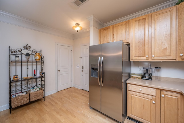 kitchen featuring light countertops, visible vents, ornamental molding, light wood-type flooring, and stainless steel refrigerator with ice dispenser