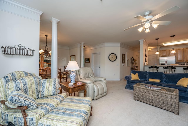 living room featuring baseboards, ornate columns, ceiling fan, carpet floors, and ornamental molding