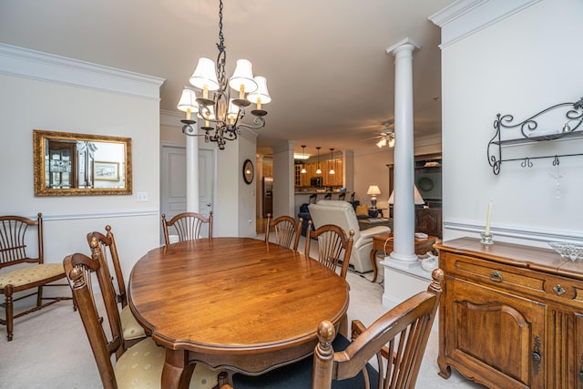 dining space with ceiling fan with notable chandelier, decorative columns, and light colored carpet