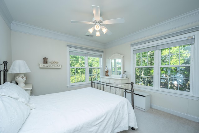 carpeted bedroom with a ceiling fan, baseboards, and ornamental molding