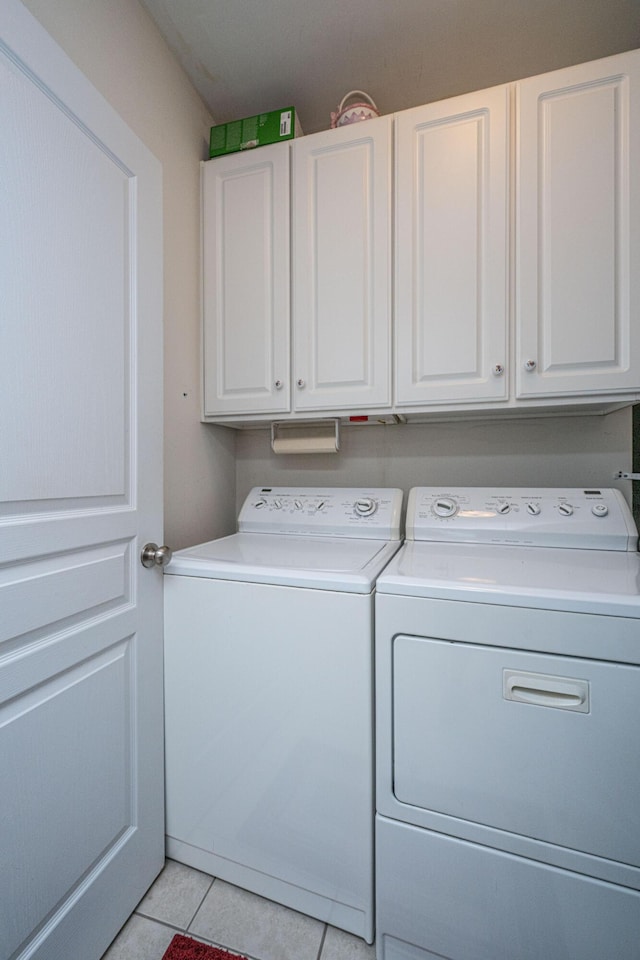 washroom with separate washer and dryer, cabinet space, and light tile patterned floors
