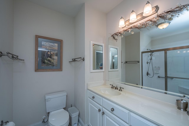 full bathroom with a stall shower, baseboards, vanity, and toilet