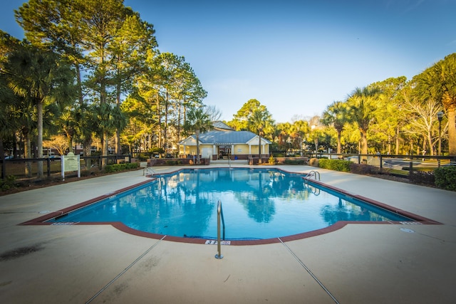 pool featuring fence and a patio area