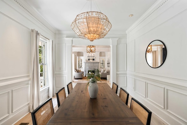 3508 Henrietta Hartford Rd, Mount Pleasant, SC 29466 - dining space with a decorative wall, a chandelier, crown molding, and light wood-style floors