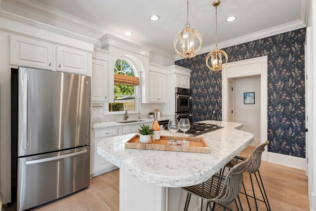 3508 Henrietta Hartford Rd, Mount Pleasant, SC 29466 - kitchen featuring stainless steel appliances, a chandelier, a sink, light wood-style flooring, and ornamental molding