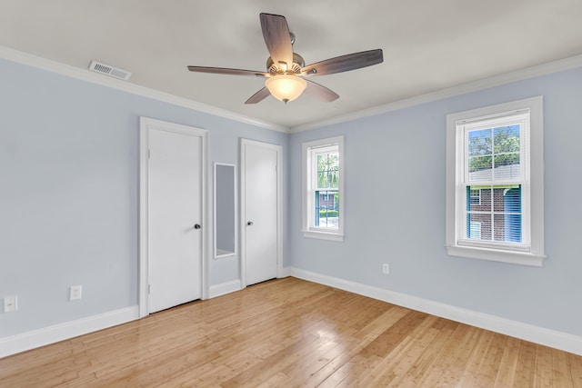 21 Rivers Point Row Unit 17G, Charleston, SC 29412 - unfurnished bedroom with two closets, multiple windows, baseboards, wood-type flooring, and crown molding