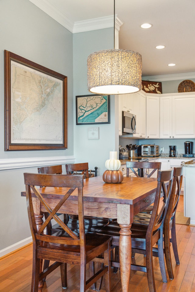 dining room with light hardwood / wood-style floors and ornamental molding