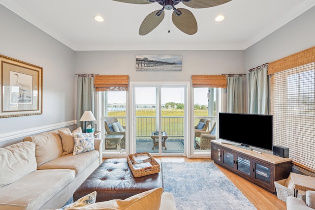 living room featuring light hardwood / wood-style flooring, ceiling fan, and ornamental molding