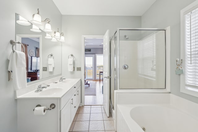 bathroom with tile patterned floors, vanity, and shower with separate bathtub