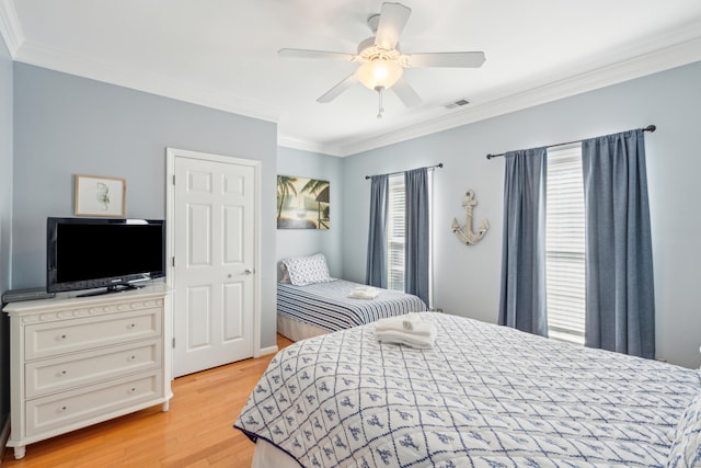 bedroom featuring light hardwood / wood-style flooring, ceiling fan, and ornamental molding