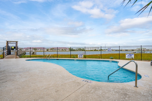 view of pool featuring a water view and a patio area