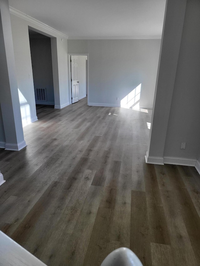 interior space with ornamental molding and dark hardwood / wood-style floors