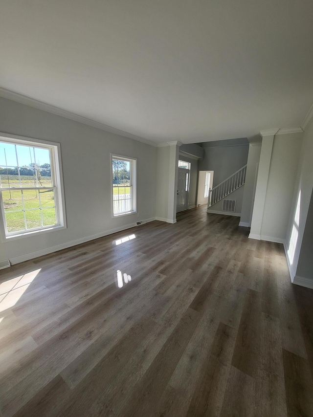 unfurnished living room featuring ornamental molding, plenty of natural light, and dark hardwood / wood-style floors