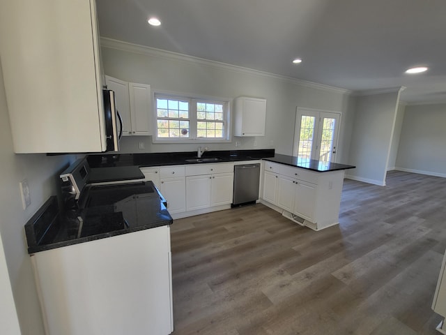 kitchen featuring a healthy amount of sunlight, appliances with stainless steel finishes, kitchen peninsula, and white cabinetry