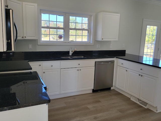 kitchen featuring white cabinetry, stainless steel appliances, sink, and light wood-type flooring