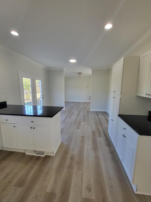 kitchen with white cabinetry, ornamental molding, light wood-type flooring, and french doors