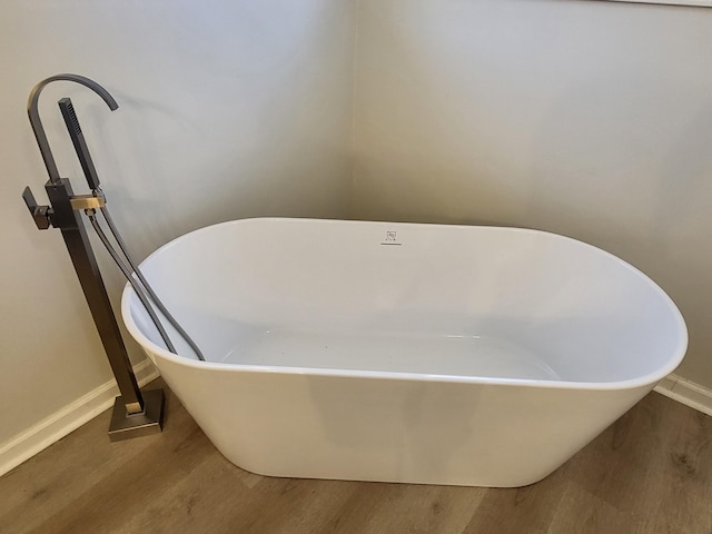 bathroom featuring wood-type flooring and a bath