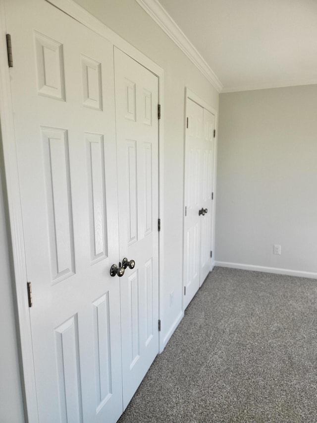 unfurnished bedroom featuring ornamental molding and dark carpet