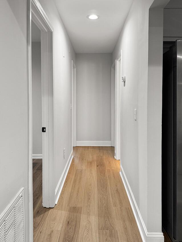 hallway with light hardwood / wood-style floors