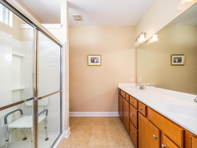 full bathroom with tile patterned floors, a stall shower, and a sink