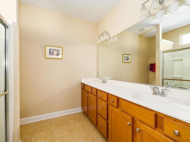 bathroom with toilet, double vanity, an enclosed shower, and a sink