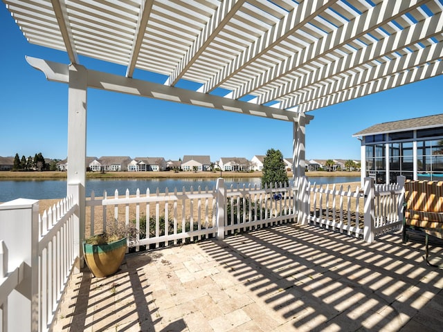 view of patio featuring a residential view, a pergola, and a water view