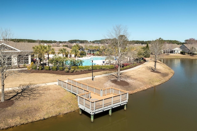 view of dock with a community pool and a water view