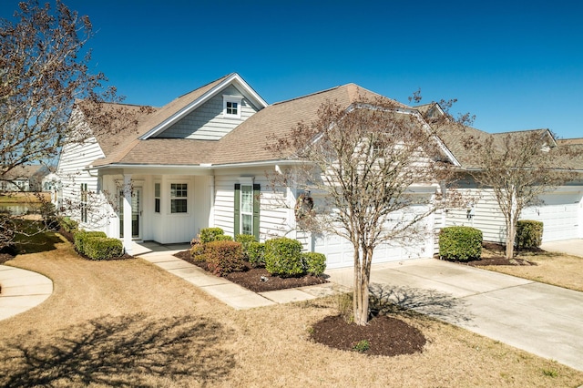 view of front of property featuring an attached garage, concrete driveway, and roof with shingles