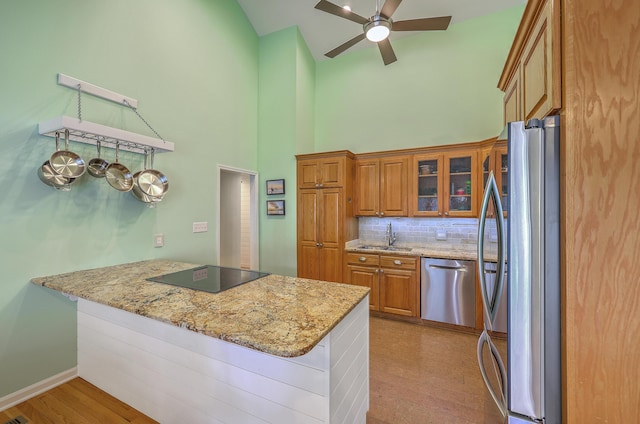 13 32nd Ave, Isle Of Palms, SC 29451 - kitchen featuring appliances with stainless steel finishes, brown cabinets, a sink, high vaulted ceiling, and ceiling fan