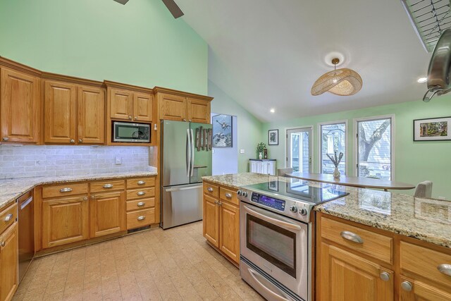 13 32nd Ave, Isle Of Palms, SC 29451 - kitchen with appliances with stainless steel finishes, decorative backsplash, light stone counters, brown cabinets, and high vaulted ceiling